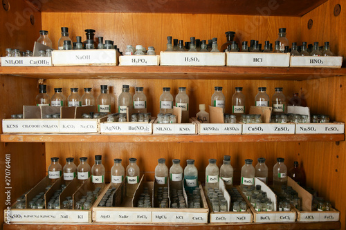 bottles with solutions are on the shelf of the chemical cabinet.