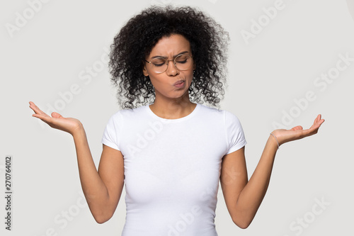 African woman on grey blank weigh the pros and cons