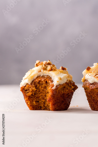 Carrot cupcakes with cream cheese frosting and caramel topping, close up