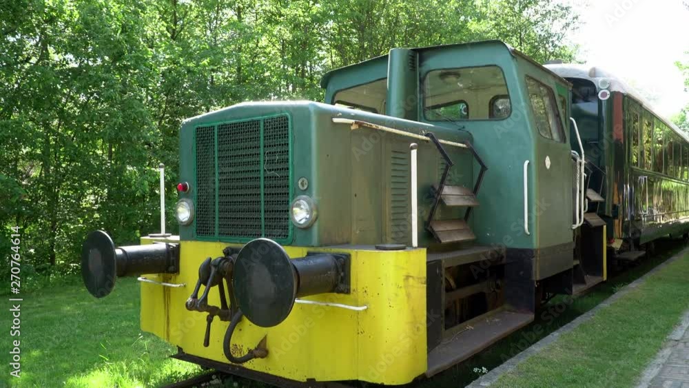 Green and yellow retro steam train on railway station in summer. Old steam locomotive. Green and yellow retro steam train on railway station in summer. Old steam locomotive.