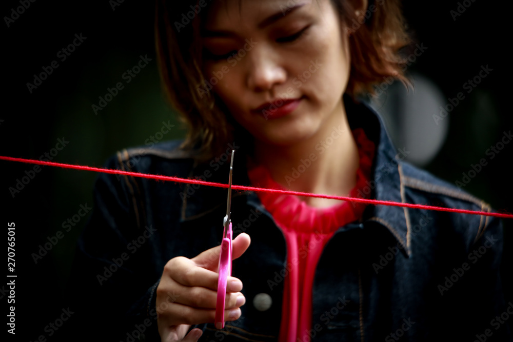 Obraz premium 赤い糸を切る女性