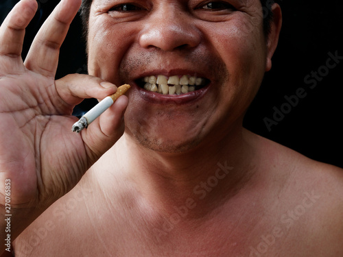 A man holding cigarette. Nicotine destroy teeth and gum healthy. it make effect Yellow stain, Tooth decay and Bad breath. world no tobacoo day.