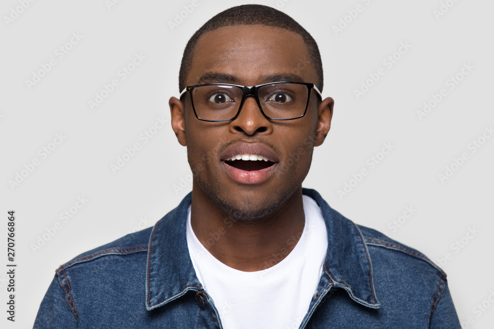 Fototapeta premium Amazed african man wearing glasses looking at camera