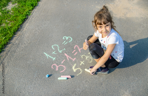 The child decides grunts on the asphalt. Selective focus. photo