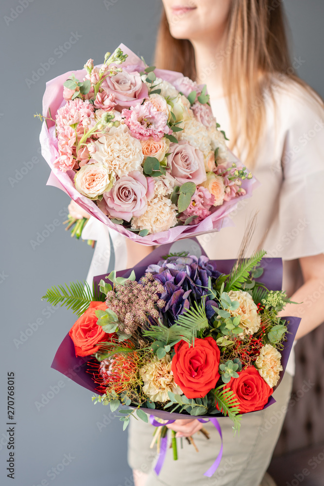 Two Small Beautiful bouquets of mixed flowers in woman hand. Floral shop concept . Beautiful fresh cut bouquet. Flowers delivery