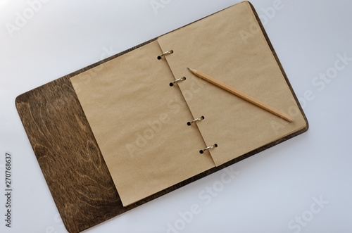 Open craft notepad with wooden cover and a pencil on white background. Mockup with space for your text
