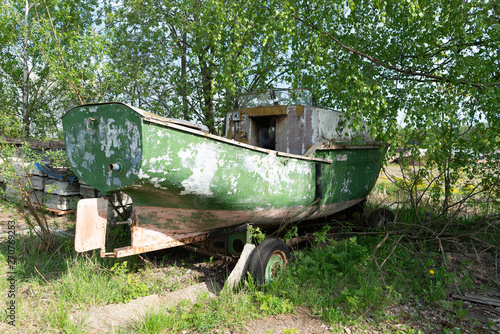 the old boat is on the shore. on wheels for transportation. in the forest