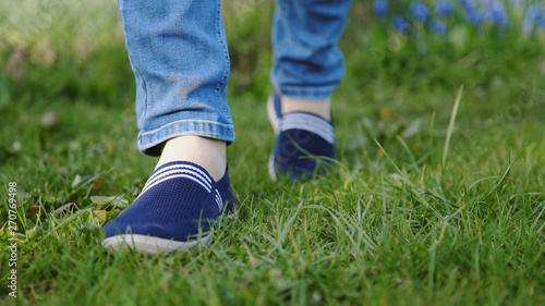 young man in red sneakers goes on a meadow