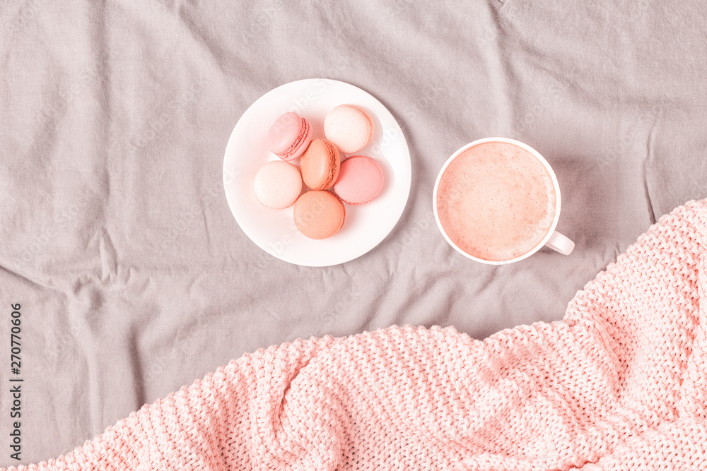 Bed with pink knitted plaid, coffee and macaroons. Bed with pink knitted plaid, coffee and macaroons.