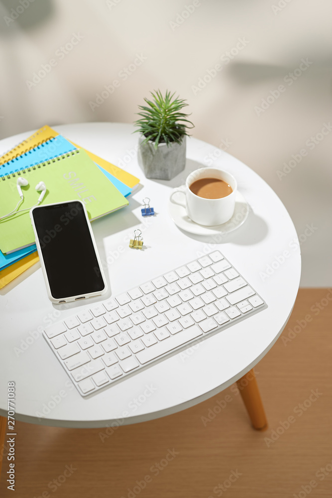 Fototapeta premium Top view office table desk.Workspace with mobile phone and office supplies on white background.
