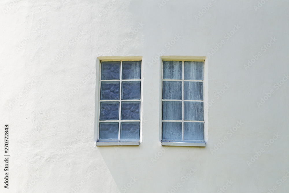 Fototapeta premium Two windows on the white wall of the house