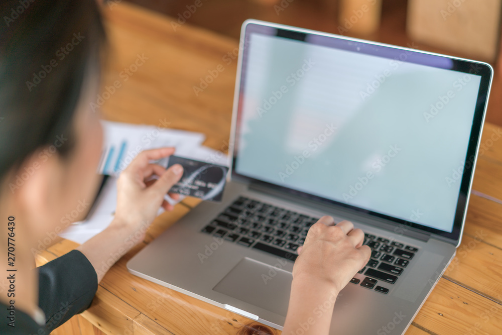 Hands holding a credit card and using laptop computer for online shopping . Hands holding a credit card and using laptop computer for online shopping .