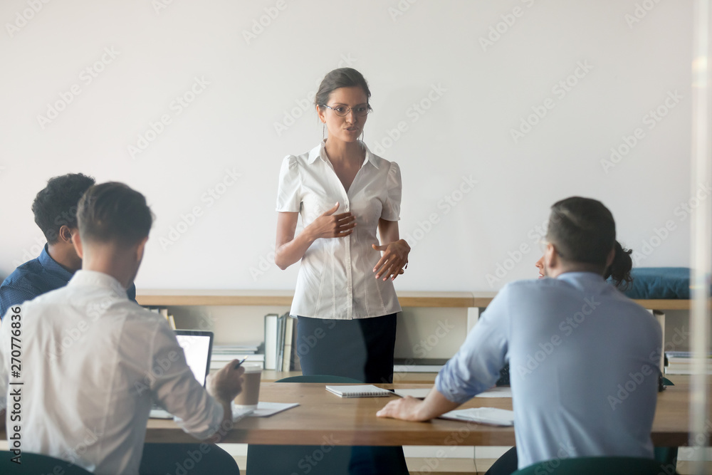 Serious female speaker talk cooperating with employees at meeting Serious female speaker talk cooperating with employees at meeting