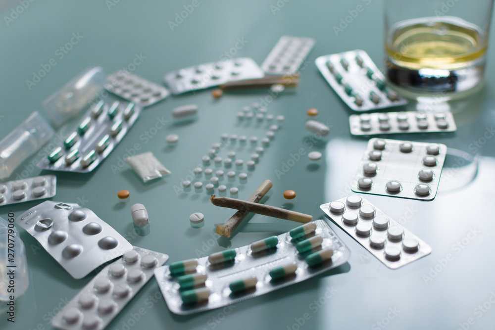 set of loose pills and complete tablets on green glass table set of loose pills and complete tablets on green glass table