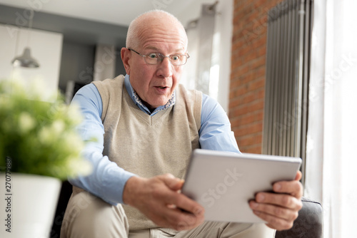 Smiling senior man using a digital tablet