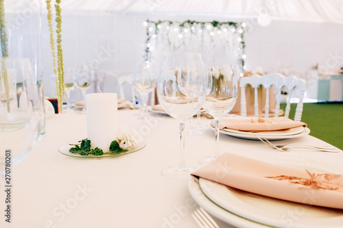 Wedding table service. Plates, glasses and flowers served on pink cloth © Stanislav