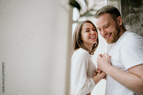 Couple in love in the bedroom. Slender brunette. Stylish interior.