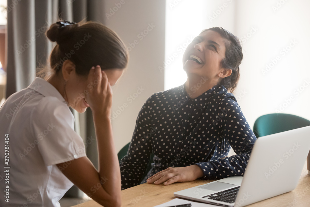 Smiling women have fun laughing at break at workplace Smiling women have fun laughing at break at workplace