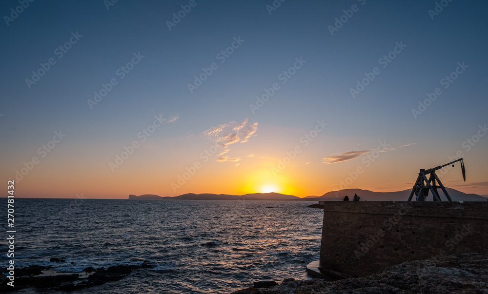 Dramatic sunset over the sea front in Alghero (L'Alguer), province of Sassari , Sardinia, Italy.