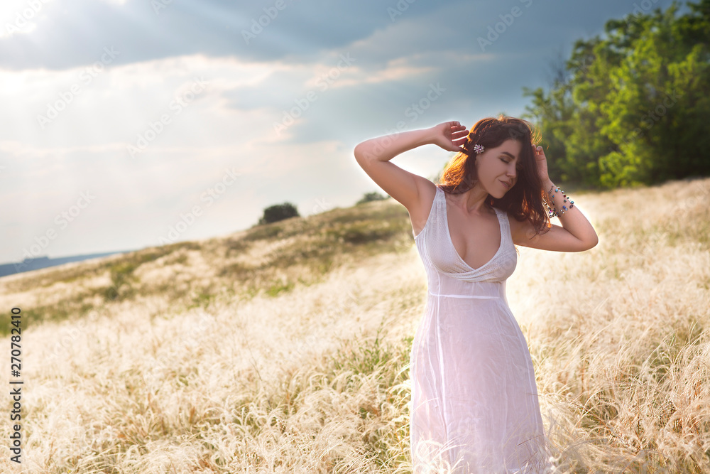 Sexy young happy woman in cute summer dress standing in the field in sunset light Sexy young happy woman in cute summer dress standing in the field in sunset light