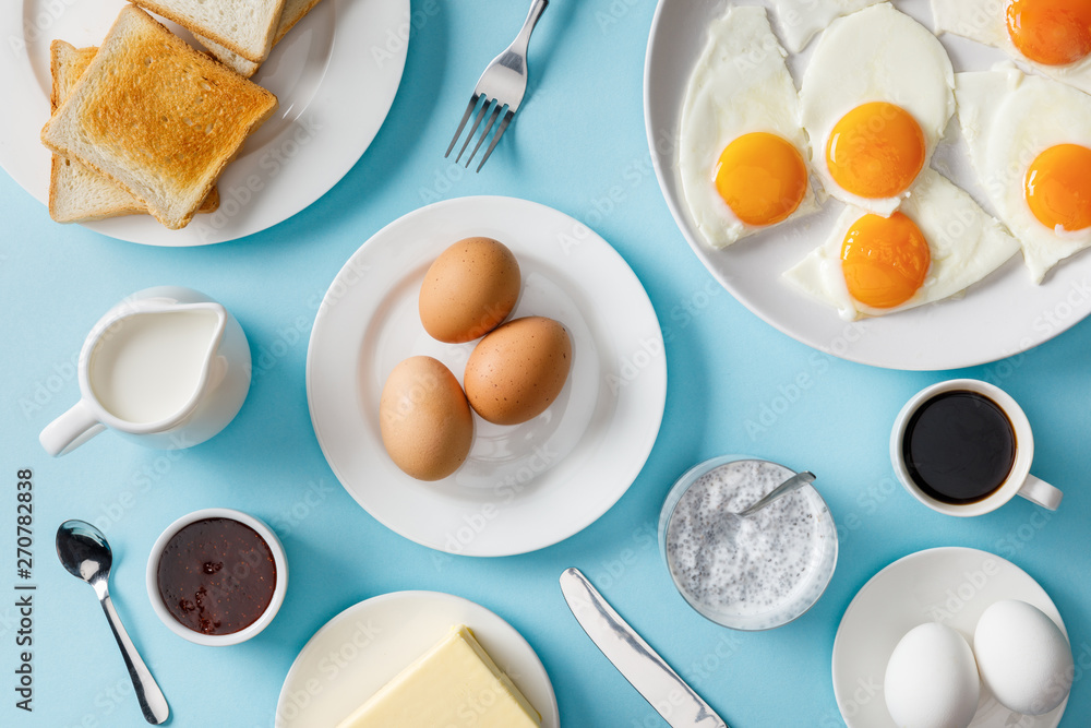 top view of served breakfast with boiled and fried eggs on blue background top view of served breakfast with boiled and fried eggs on blue background