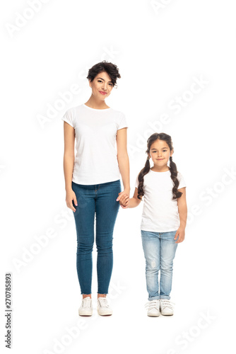 happy latin mother holding hands with cute daughter isolated on white