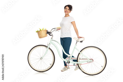 cheerful latin woman standing with bicycle isolated on white