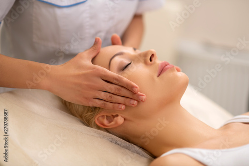 Beautiful woman enjoying face massage in beauty center