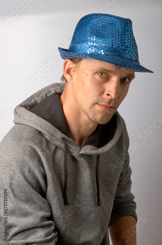 The guy in the blue hat sits on a gray background