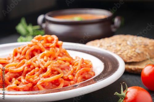 Vermicelli in tomato sauce on a dark background