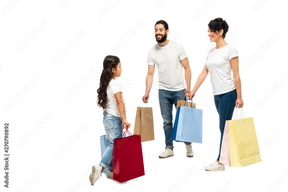 happy latin parents holding shopping bags while looking at daughter isolated on white happy latin parents holding shopping bags while looking at daughter isolated on white