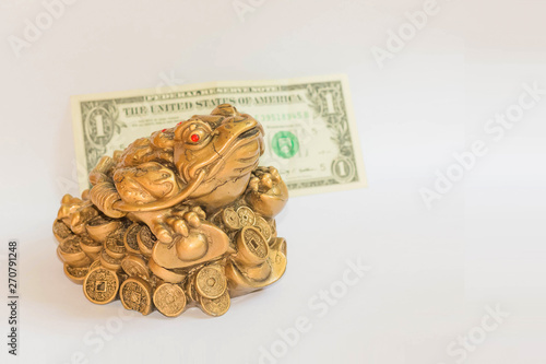 Cash mascot - Chan Chu - a gold frog figurine sitting on coins isolated on white background with dollar
