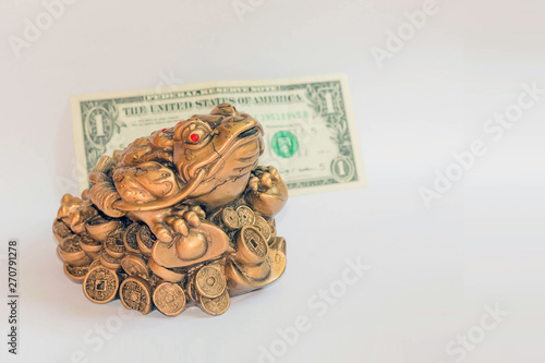 Cash mascot - Chan Chu - a copper frog figurine sitting on coins isolated on white background