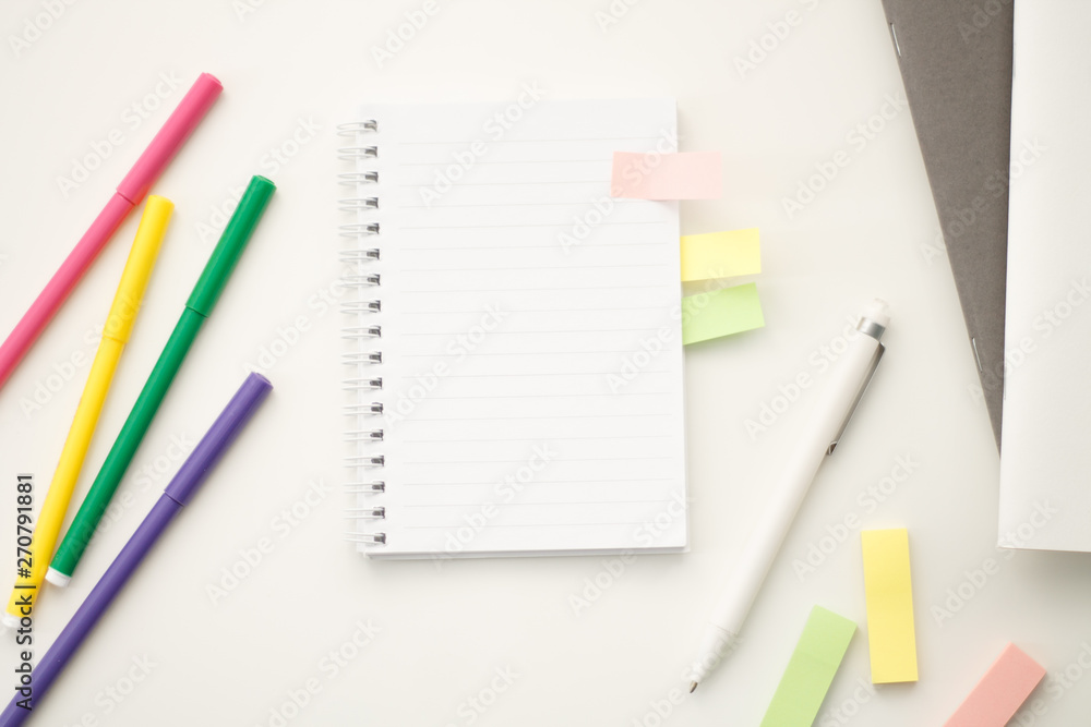 white notebook with springs sheets in line on a white background with a white pen markers colored stickers lying next to notebooks white notebook with springs sheets in line on a white background with a white pen markers colored stickers lying next to notebooks