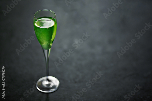 Absinthe in a glass on black background photo