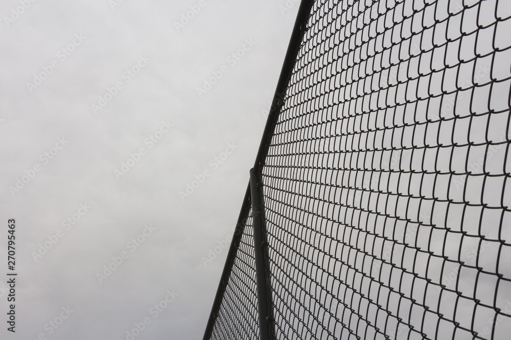 Looking Looking up at the protective metal fence and iron mesh outside the city sports fieldup at the protective metal fence and iron mesh outside the city sports field Looking Looking up at the protective metal fence and iron mesh outside the city sports fieldup at the protective metal fence and iron mesh outside the city sports field