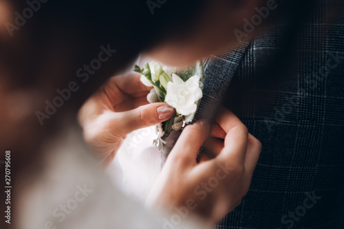 Fotografie stylish groomsmen helping happy groom getting ready in the morning for wedding ceremony