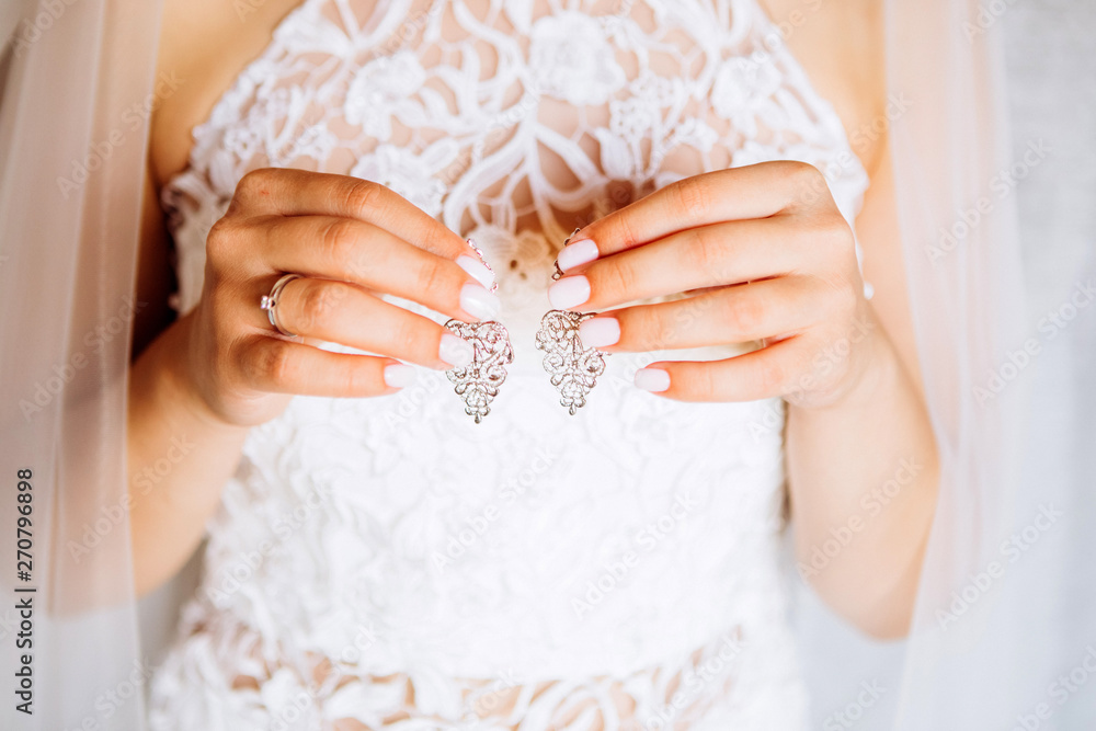 Beautiful earrings on the palm of the bride Beautiful earrings on the palm of the bride