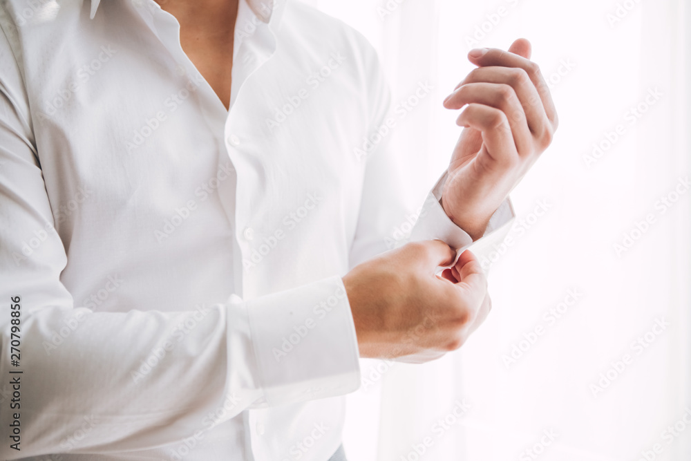 stylish groomsmen helping happy groom getting ready in the morning for wedding ceremony. luxury man in suit in room. wedding day. stylish groomsmen helping happy groom getting ready in the morning for wedding ceremony. luxury man in suit in room. wedding day.