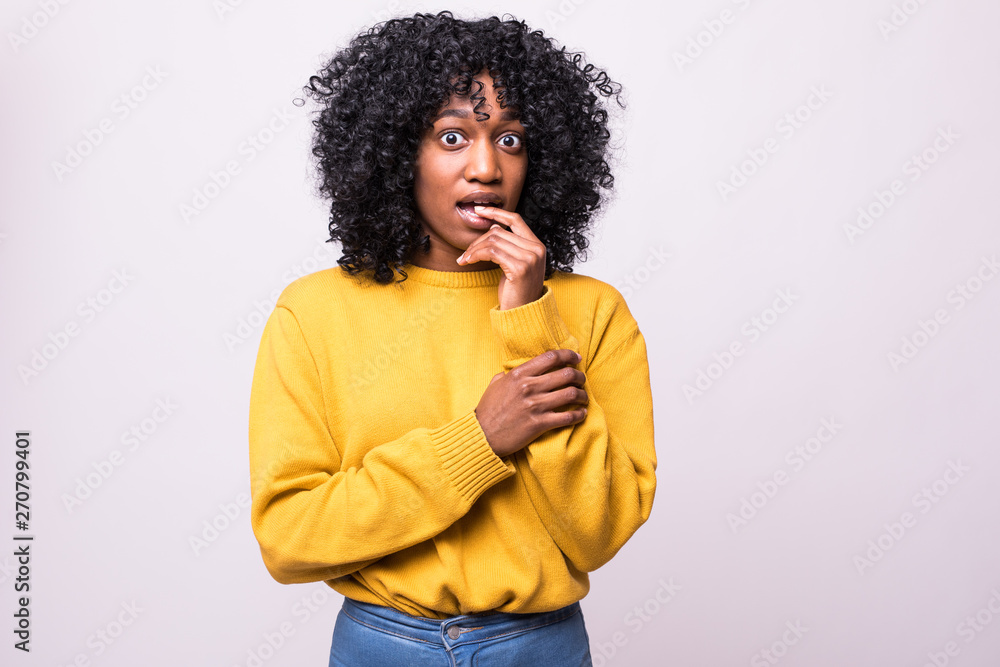 Headshot of beautiful scared young african woman with curly hairstyle closing mouth not to scream, feeling frightened and terrified, her eyes and look full of fear and terror Headshot of beautiful scared young african woman with curly hairstyle closing mouth not to scream, feeling frightened and terrified, her eyes and look full of fear and terror