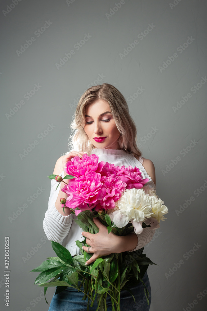 Portrait woman holding pink bouquet of peonies. space for text. spring girl with flowers