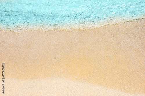 Soft wave of turquoise sea water on the sandy beach