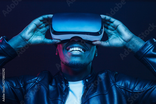 African man wearing virtual reality headset having great fun photo