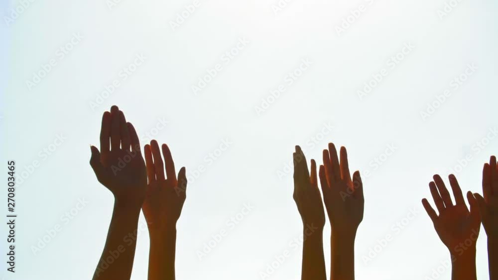 Tracking shot of human arms raised against the sky and wiggling Tracking shot of human arms raised against the sky and wiggling