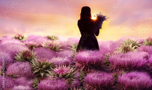 The girl is among the giant lilac flowers. Fantasy picture.