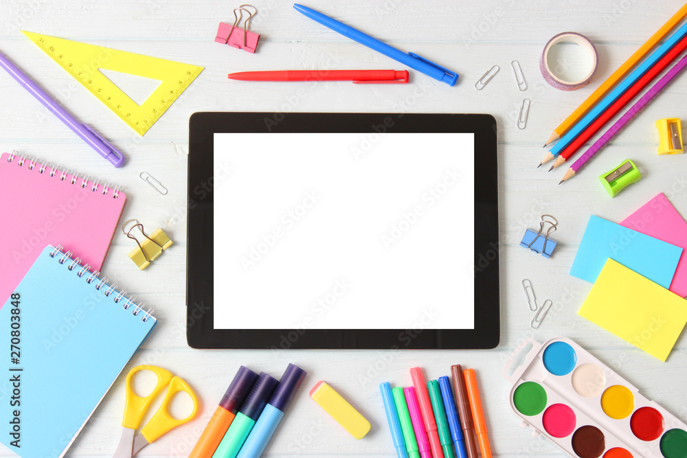 Modern digital tablet and school stationery on a colored background top view. Kontpt back to school. Place for text. Modern digital tablet and school stationery on a colored background top view. Kontpt back to school. Place for text.