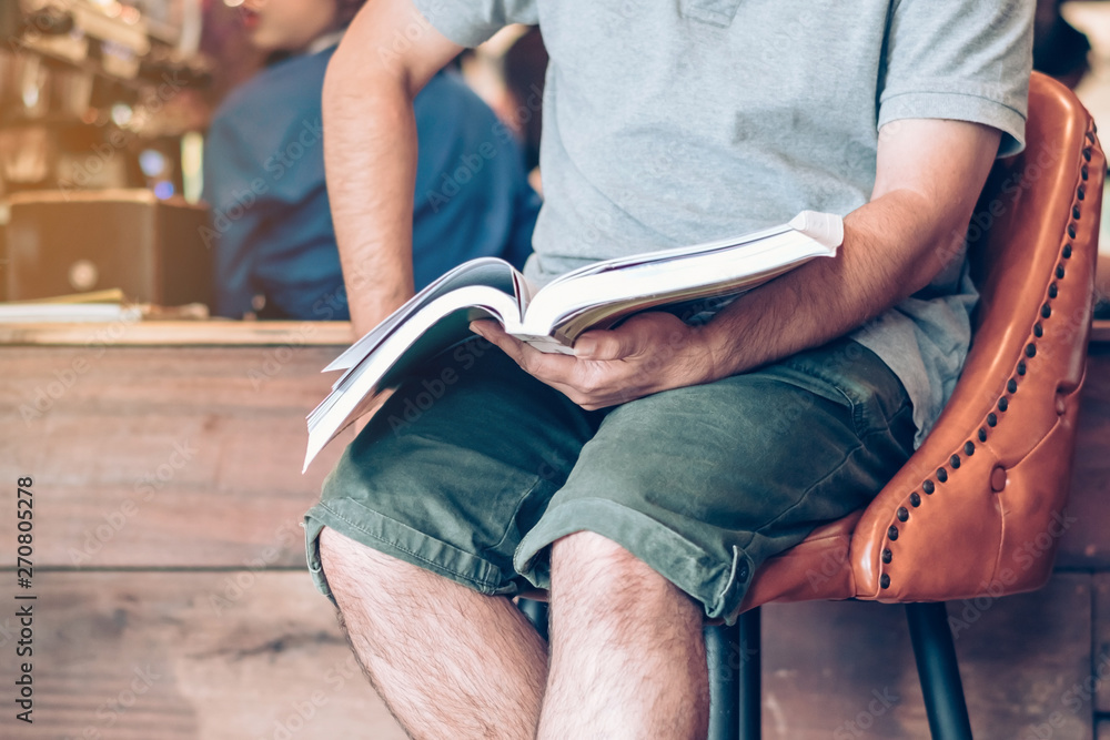 Fototapeta premium Asian man read a book in a coffee shop.