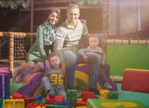 young parents and kids having fun at childrens playroom photo