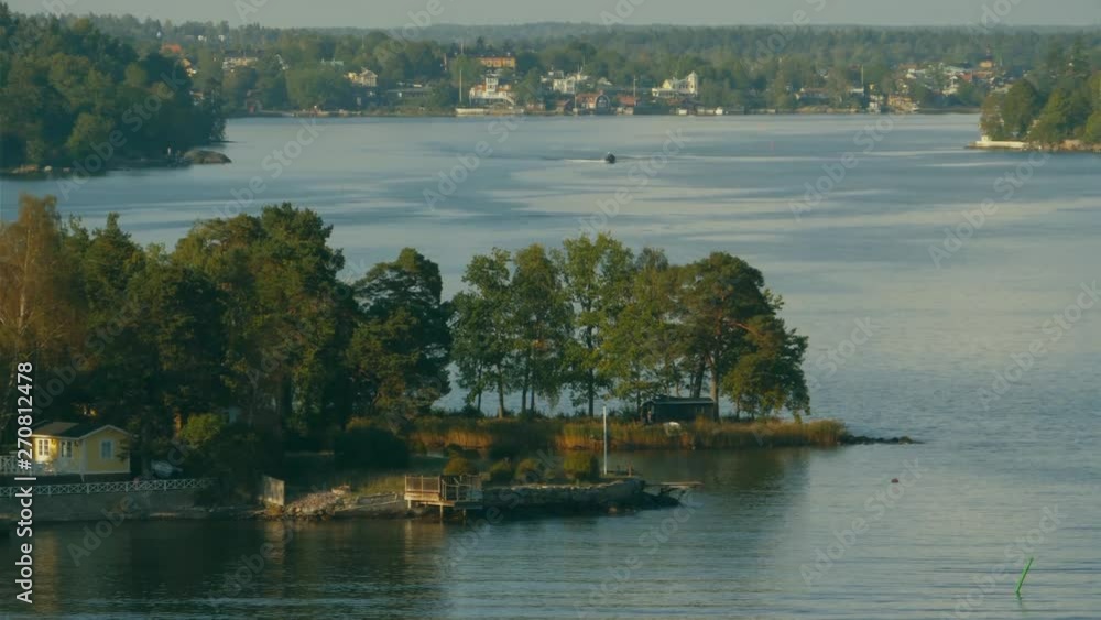 A copse of trees located on a small island of an archipelago with nearby land also covered in trees. A copse of trees located on a small island of an archipelago with nearby land also covered in trees.