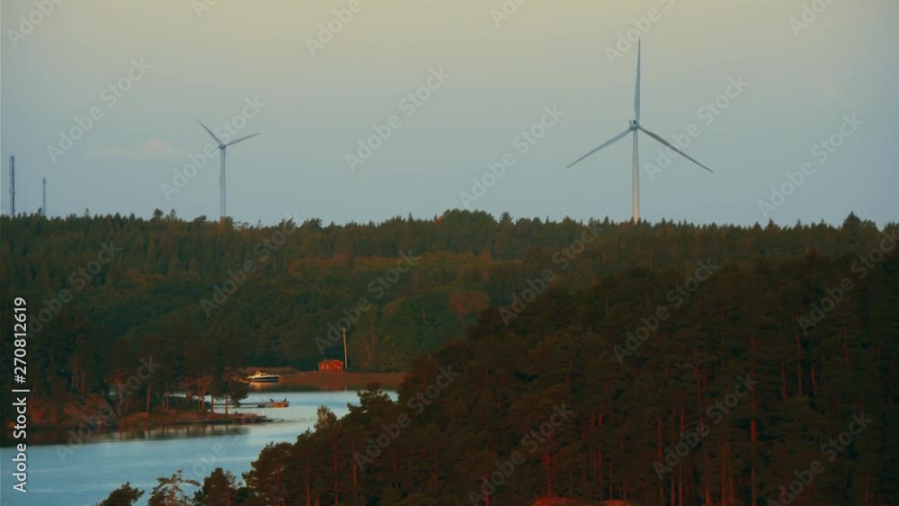 custom made wallpaper toronto digitalAn aerial view of a pair of wind turbines generating clean energy atop hills surrounded by water.